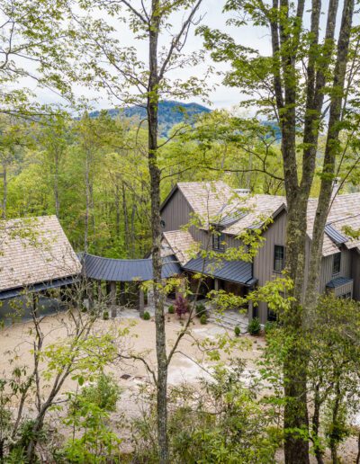 An aerial view of a home in the woods.