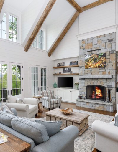 A living room with wood beams and a fireplace.