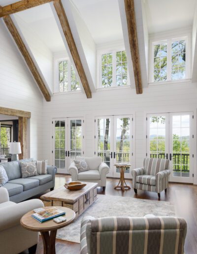 A living room with wood beams and a stone fireplace.