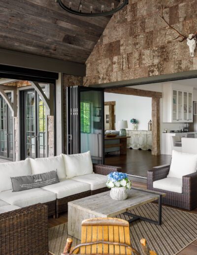 A porch with rocking chairs and wicker furniture.