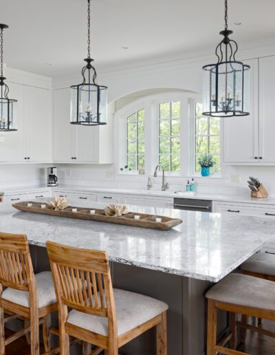 A kitchen with a large island and chairs.