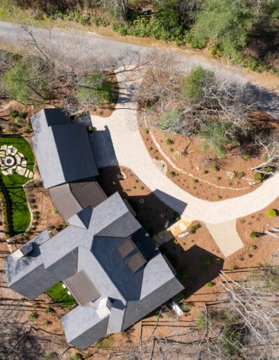 An aerial view of a house in the woods.