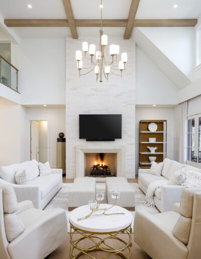 A living room with white furniture and a fireplace.