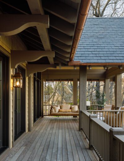 A porch with wooden railings and a fireplace.
