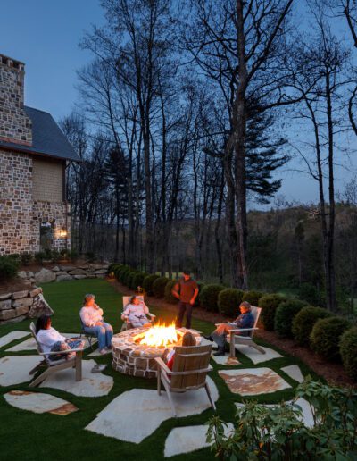 A group of people sitting around a fire pit.