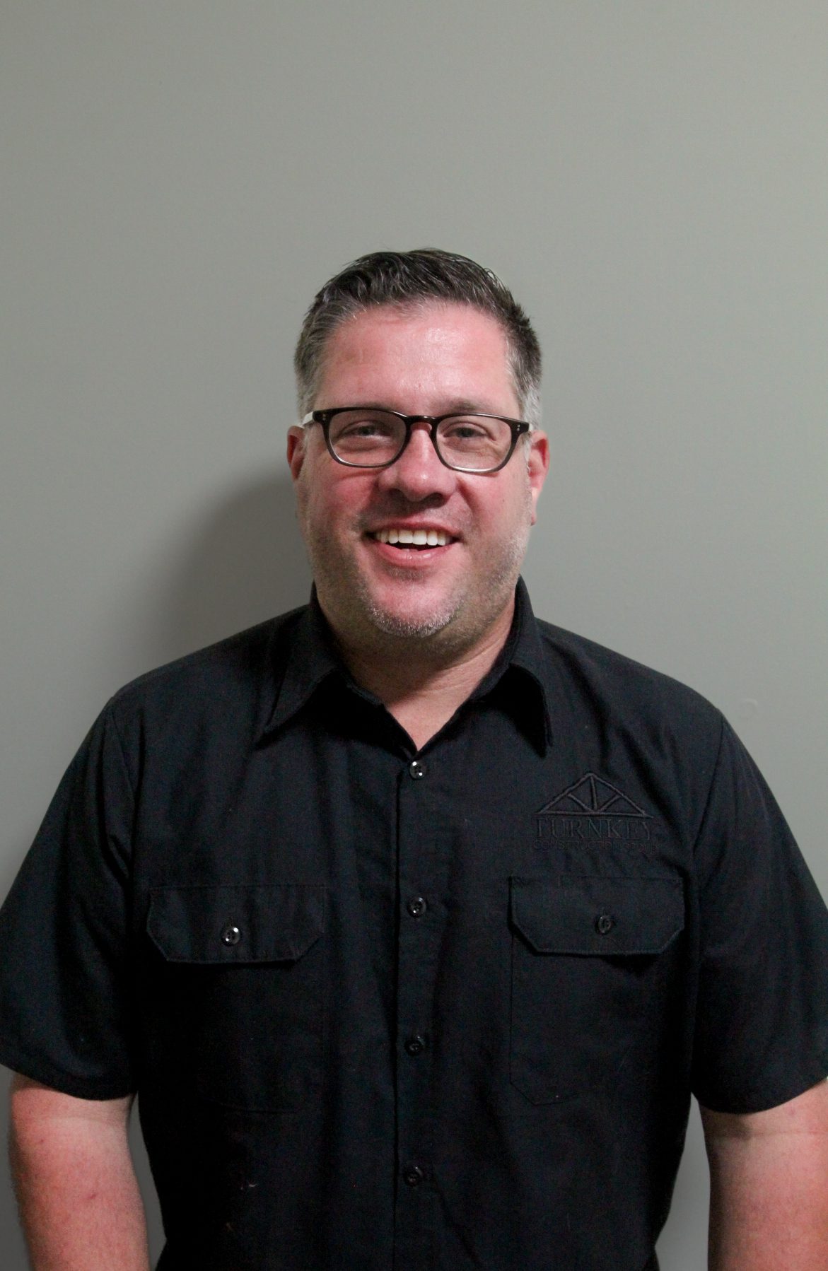 A man wearing glasses and a black shirt.
